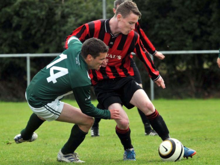 Enda Purcell (Spa United) keeps control of the ball as Padraig Crawford (Tullaroan) challenges during their Division One clash on Sunday. Spa took the spoils with a 3-2 win. Photo: Michael Brophy