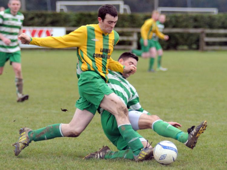 Michael O'Neill (East End United A) gets past the sliding challenge of Graham Gohery (Evergreen B). Photo: Michael Brophy