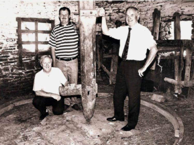 Seamus Hahessy, Patrick Holohan and Dr Michael Conry among the remnants of the wooden churning gear in Michael "Bawn" Brennan's machine house in Coon West in 1993 which was used in 1993 for housing young drystock.