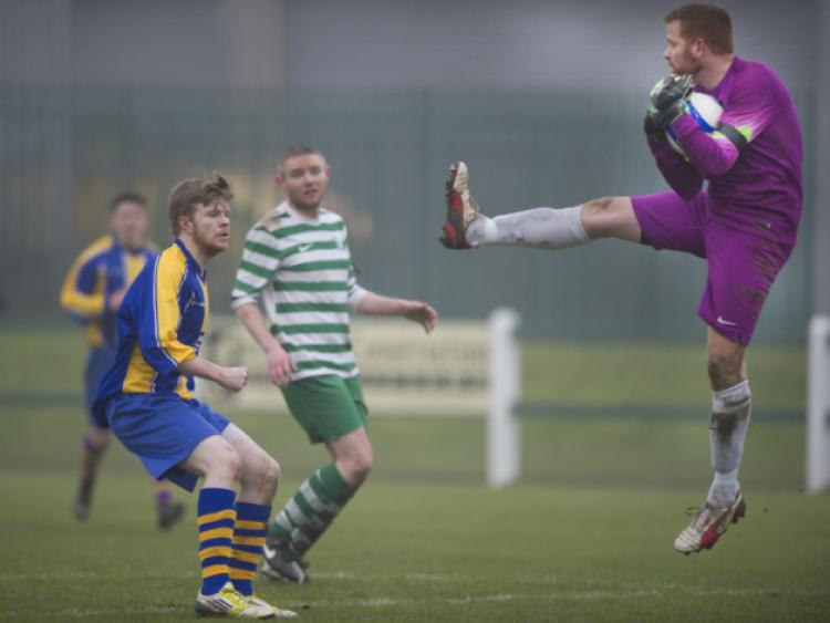 Mark McGrath (St Michael's) makes sure to stop his run as Pat Holden (Evergreen) leaves his line to make this catch during Sunday's FAI Junior Cup clash in Tipp Town. Photo: Joe Kenny