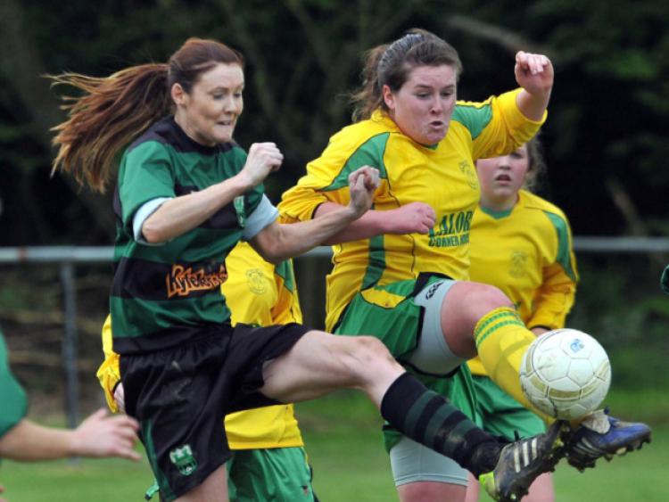 Niamh Bolger (East End United) makes the clearance as Breda O'Neill (Tullaroan) closes in during the Women's Division One play-off in Derdimus. Photo: Michael Brophy