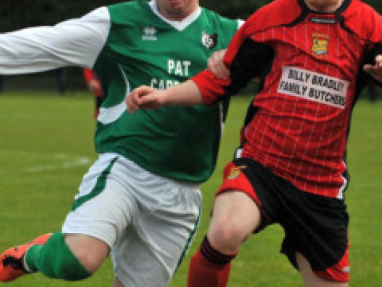 Tony Delaney (Newpark United A) stretches to reach the ball as Patrick Rudkins (Brookville) tries to hold him off during Sunday's McCalmont Cup final at Derdimus. Photo: Michael Brophy