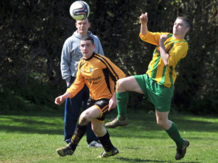 It's all eyes on the ball for Robbie Ryan (East End United A) and Daniel Walsh (AC Kilkenny A) during Sunday's Division One clash in Bennettsbridge. Looking on is East End manager John Maddock.