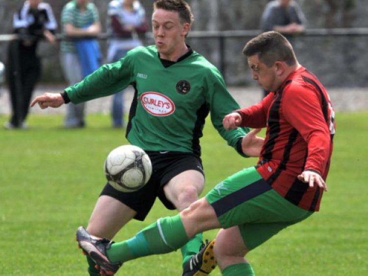 Jimmy Fox (Clover United) clears the ball despite the pressure from Liam Hickey (Freshford Town) during the Buckley Youths' Cup final at Derdimus. Photo: Michael Brophy