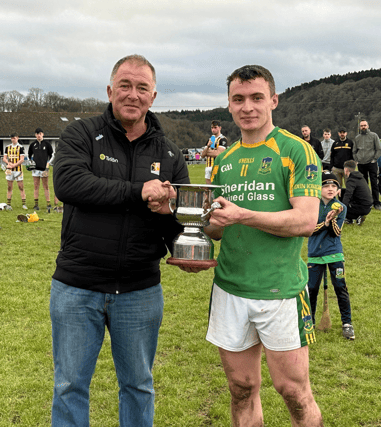 Dunnamaggin captain Denis Walsh receives the Under 21 Roinn B trophy from Junior Board Chairman Paddy Cooney.