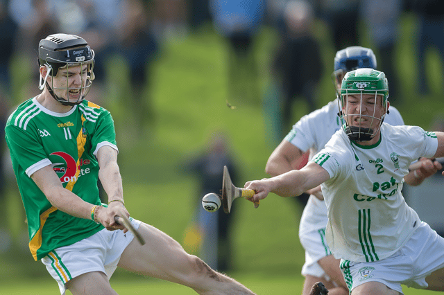 Carrickshock’s Eoghan O’Neill gets a shot away despite the close attention of O’Loughlin Gaels corner back Ruaidhri Galwey during last Sunday’s Intermediate relegation final in John Locke Park.
