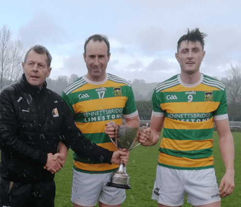 Nicky Cleere and Kevin Blanchfield receive the Junior Trophy from Kilkenny county Board Vice Chaiperson Jim Fennelly.