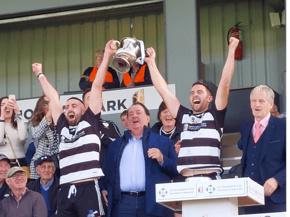 Blacks and Whites joint captains Joe Kelly and Paul Murphy lift the junior cup
