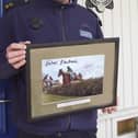 Gda Stephen Murphy from Muckalee and stationed in Durrow, holding the signed photo of Rachael Blackmore which will be auctioned off by Sheppard's of Durrow on June 11 in aid of The Little Blue Heroes