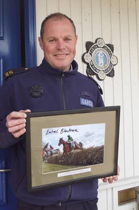 Gda Stephen Murphy from Muckalee and stationed in Durrow, holding the signed photo of Rachael Blackmore which will be auctioned off by Sheppard's of Durrow on June 11 in aid of The Little Blue Heroes
