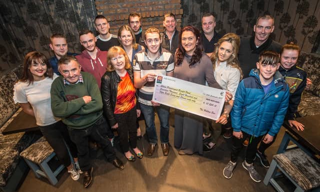 Shane Prendergast is presented with a cheque for the money raised by the benefit night held by the Hilltop Bar in Ballymurphy PICTURE: PAT MOORE