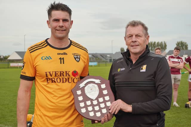 Piltown captain Kevin Walsh receives the Junior Shield From Kilkenny Vice-Chair Jim Fennelly.