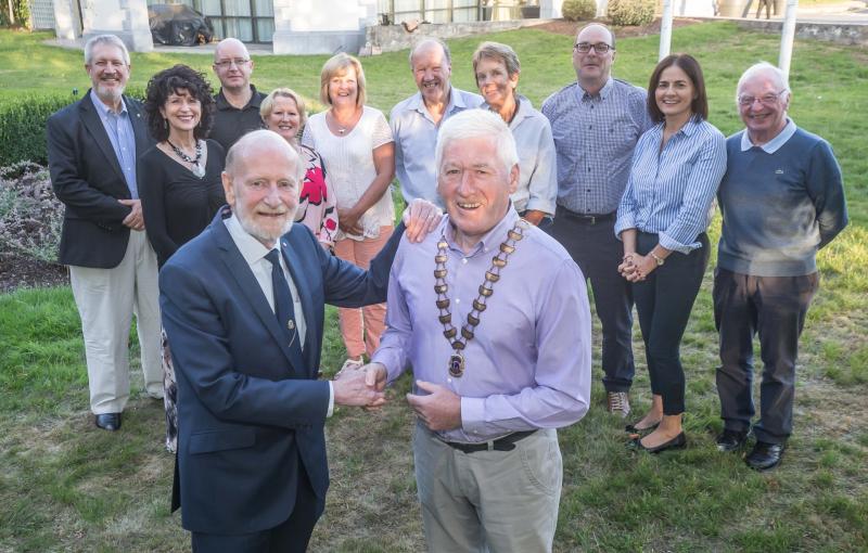 Philip Tierney accepts the Presidents chain from Brian O'Callaghan at the Newpark Hotel  last weekl, with Lions club members in the background PICTURE: PAT MOORE