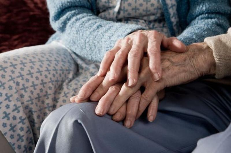 elderly couple holding hands