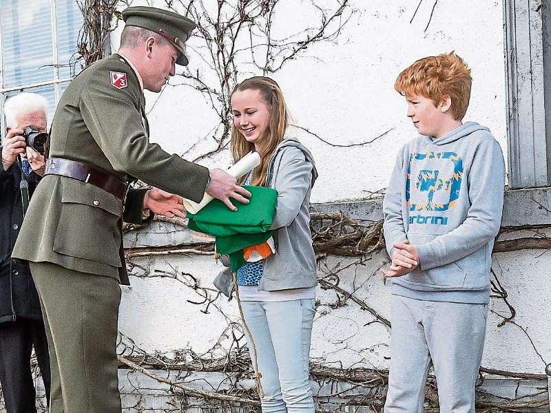 Lt Kealan O' Toole gives Mike White Ferris the Irish flag during a commemoration ceremony last March.