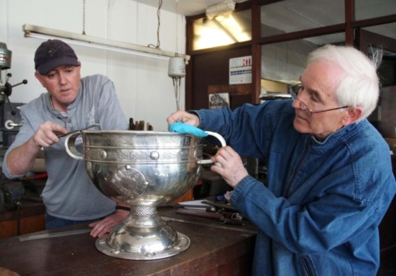 Silversmiths Des Byrne (right) and David Byrne with the Sam Maguire in their workshop for refurbishment. Picture: Michael Brophy