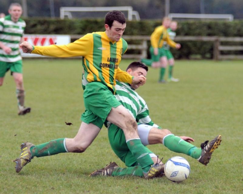Michael O'Neill (East End United A) gets past the sliding challenge of Graham Gohery (Evergreen B). Photo: Michael Brophy