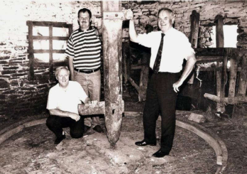 Seamus Hahessy, Patrick Holohan and Dr Michael Conry among the remnants of the wooden churning gear in Michael "Bawn" Brennan's machine house in Coon West in 1993 which was used in 1993 for housing young drystock.