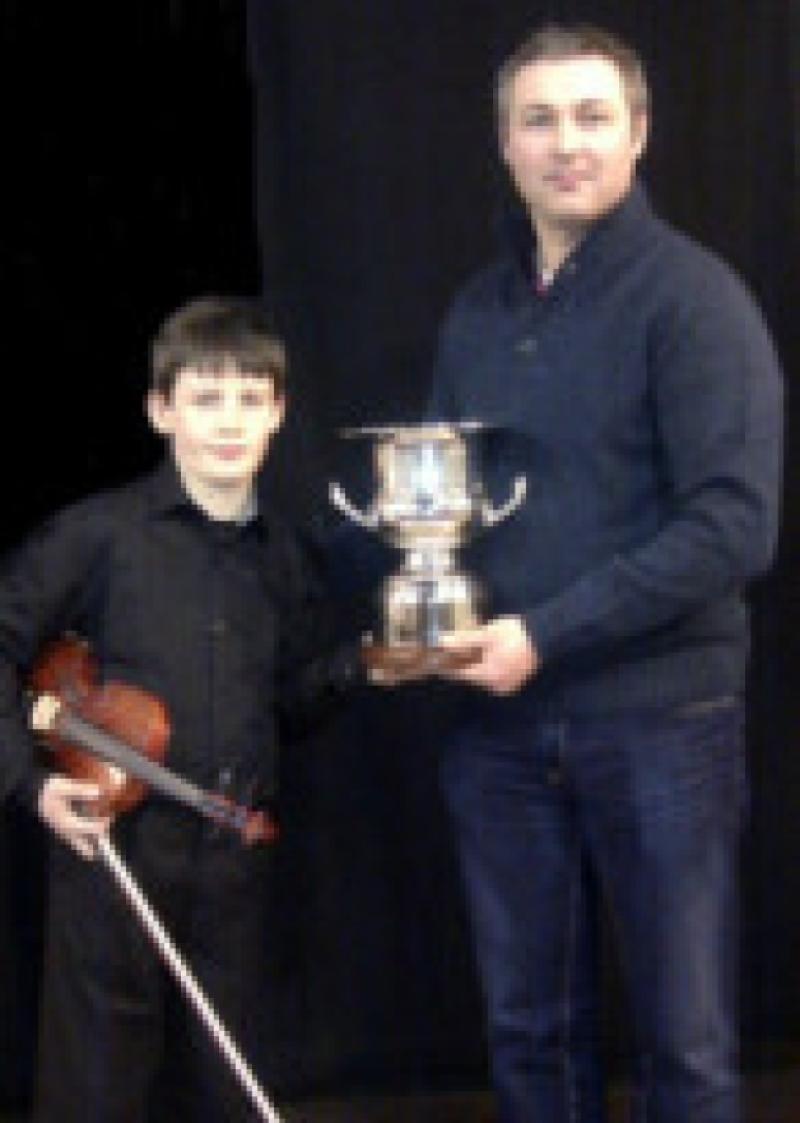 Adam Walker being presented with the Canon Brennan Memorial Cup for Emerging Talent with the Bank of Ireland Bursary by Adjudicator Niall Crowley.