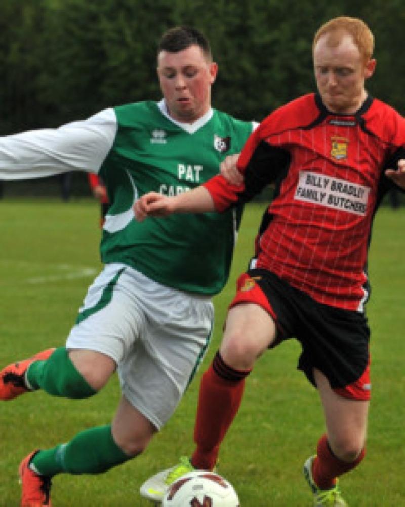 Tony Delaney (Newpark United A) stretches to reach the ball as Patrick Rudkins (Brookville) tries to hold him off during Sunday's McCalmont Cup final at Derdimus. Photo: Michael Brophy