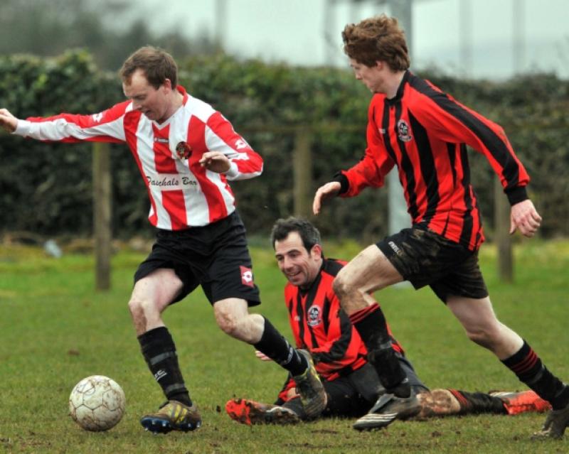 Ramie Moriarty (Spa United) skips clear of Johnny Dowling and Neil Murtagh (Deen Celtic) during Sunday's Division One league tie in Johnstown. Photo: Michael Brophy
