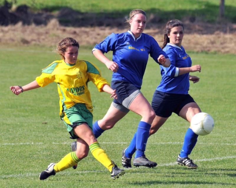 Becky Walsh (East End United) scores from this shot despite the attention of Anna Brown and Zoe Power (Benefica). Photo: Michael Brophy